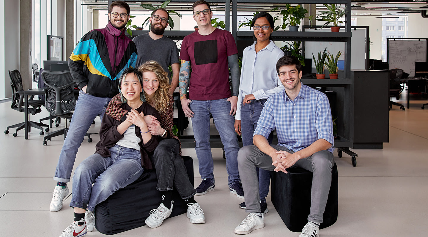 A group of diverse employees smiling at the camera and interacting with each other