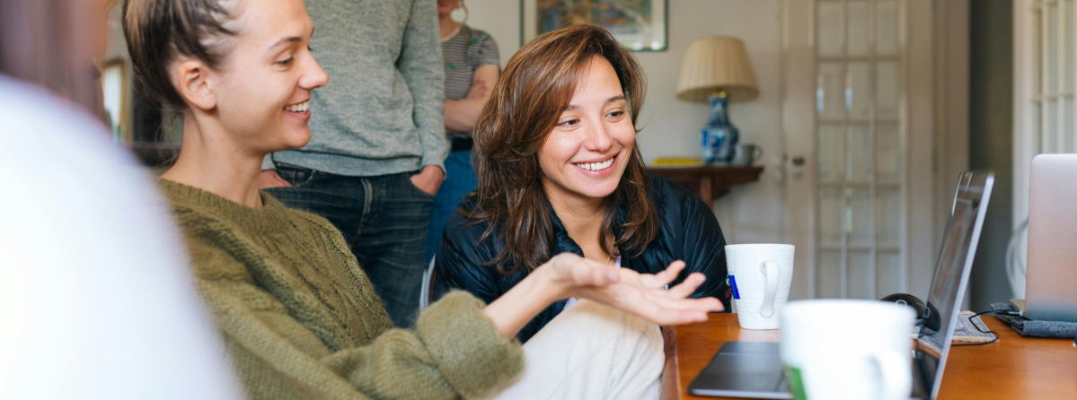 Zwei Frauen suchen am Computer nach Nebenjobs von zu Hause aus