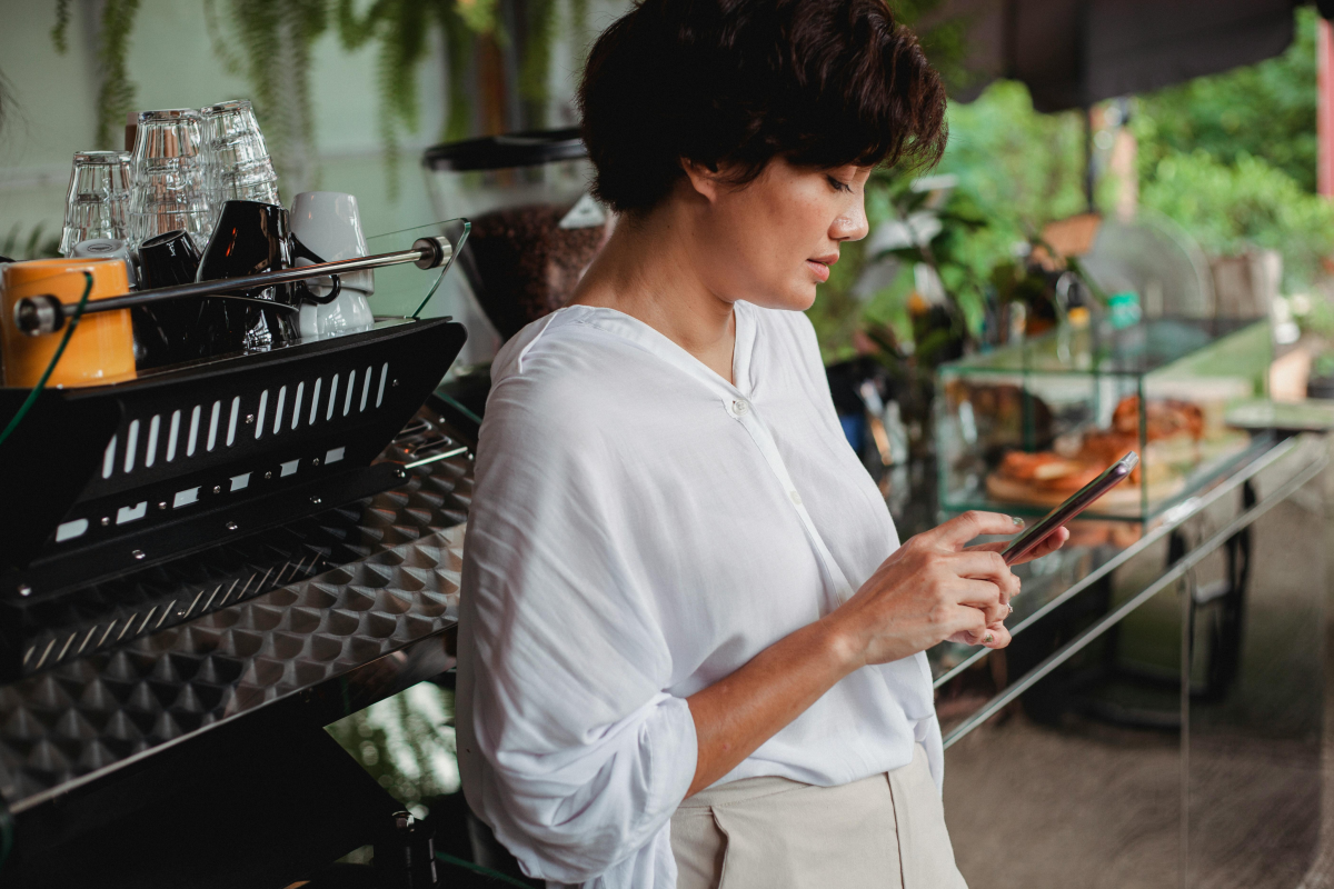 Frau bearbeitet Kassenbuch und Belege digital am Smartphone