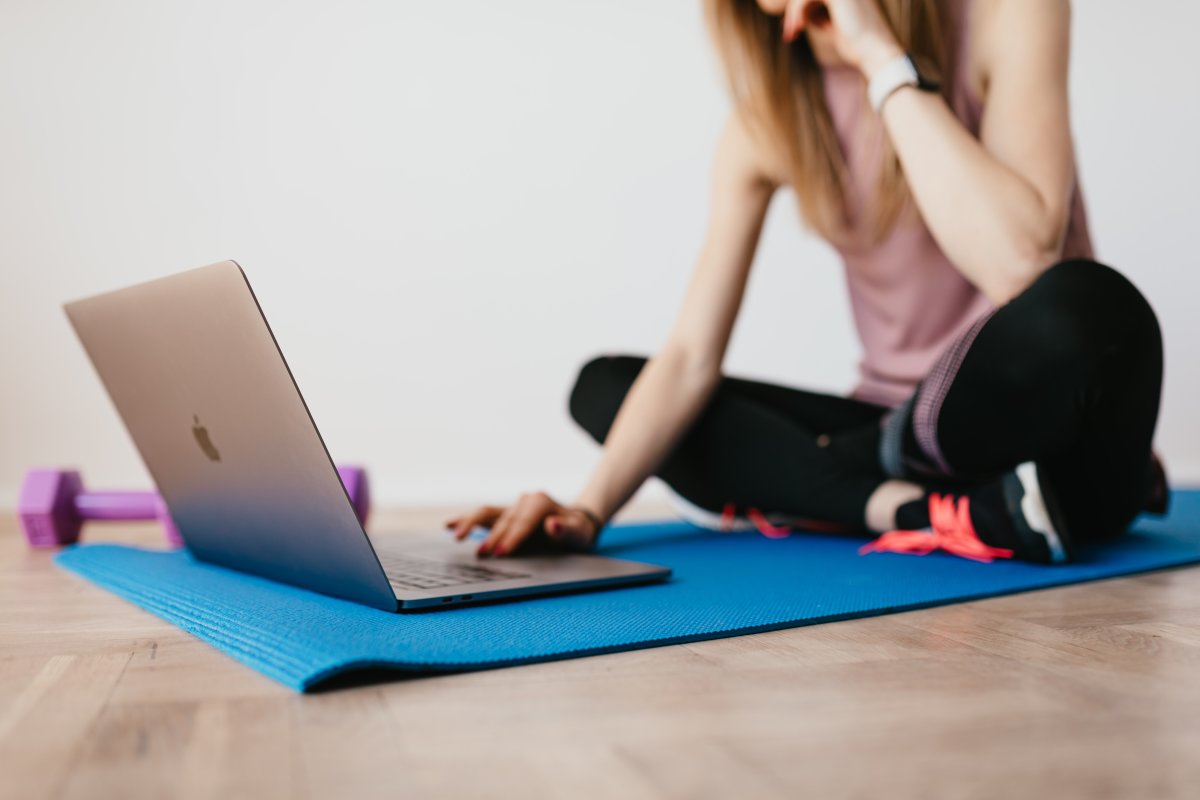 Woman on yoga mat with macbook