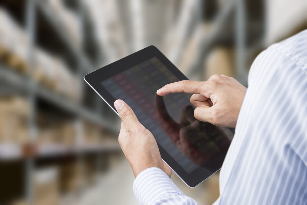 Warehouse worker tracking inventory on a tablet