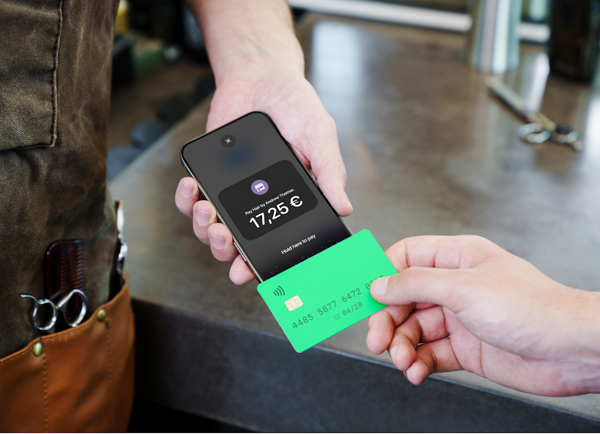 Image of someone tapping their card on an iPhone to pay