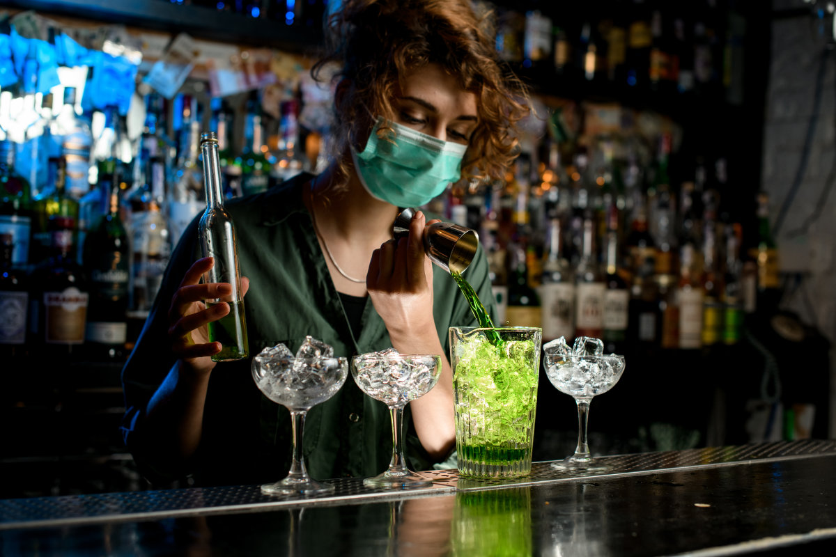 Une barmaid portant un masque travaille durant la pandémie de COVID-19.