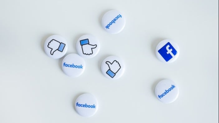 8 facebook buttons with the word, logo and thumbs up placed on white table