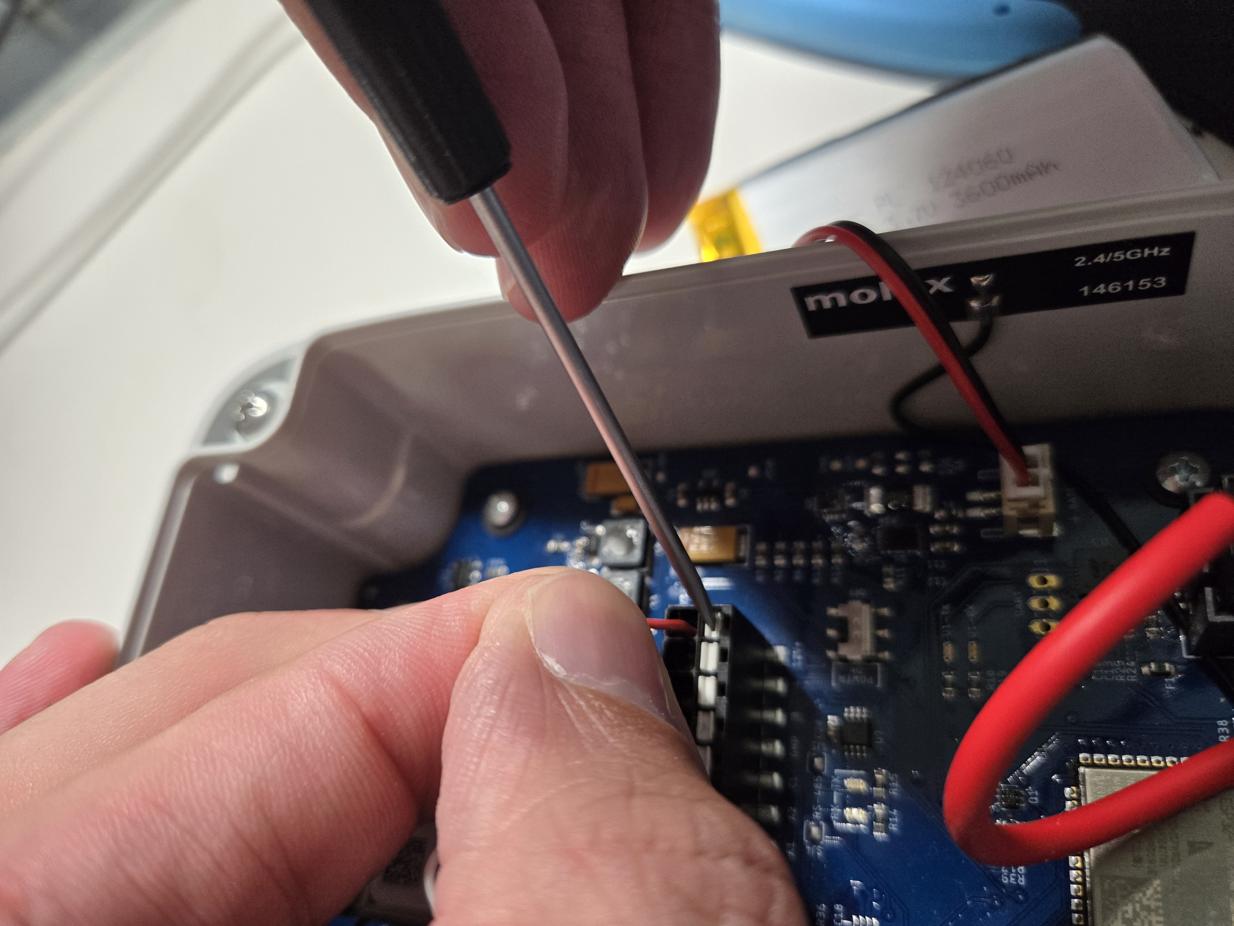 Hand connecting wires to the terminal block of a node