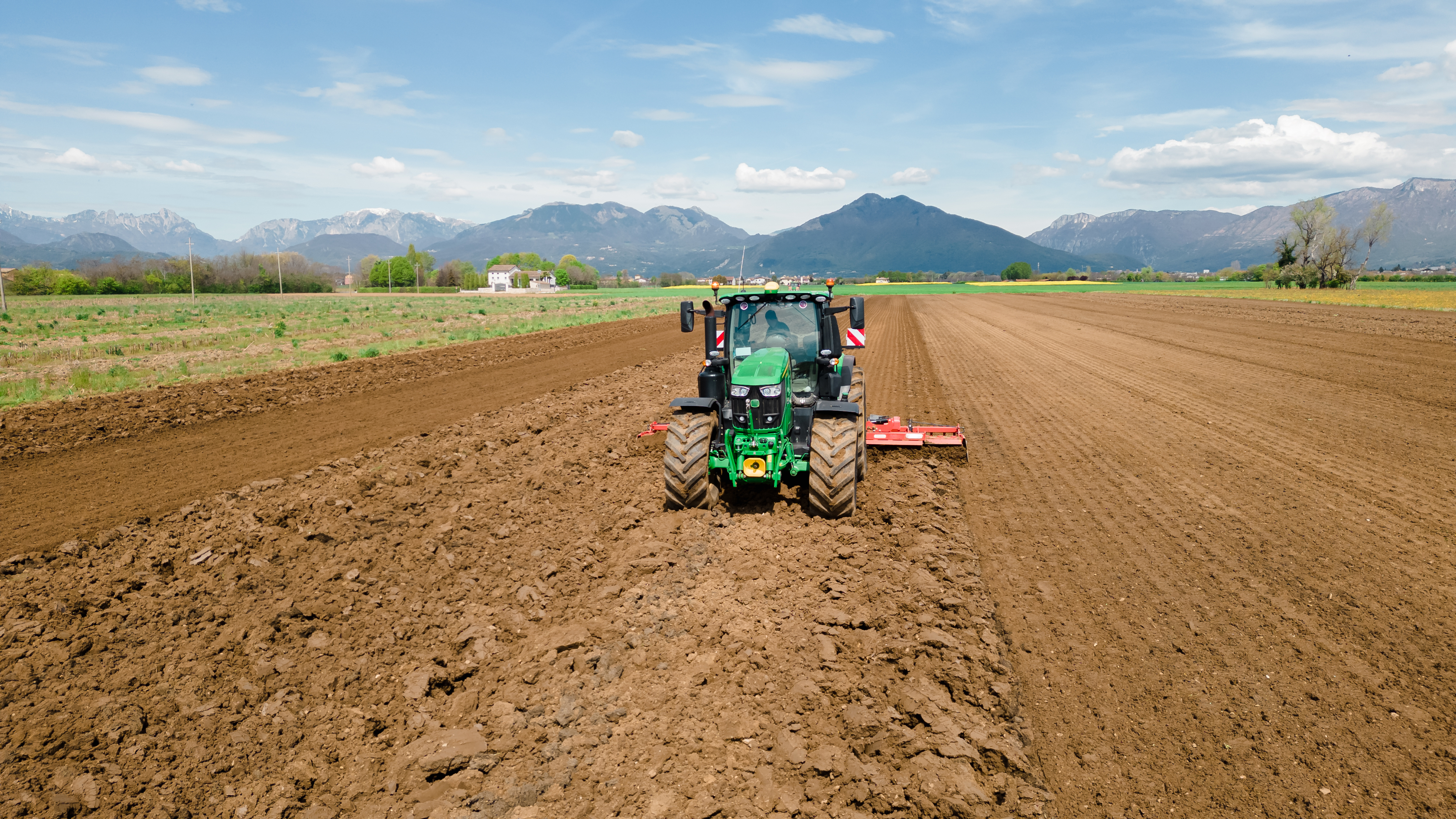 Tractor in a field monitored with neatMon automated monitoring nodes