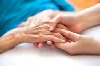Holding an elderly woman's hand in support