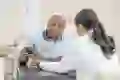 Doctor teaching patient how to use a tablet