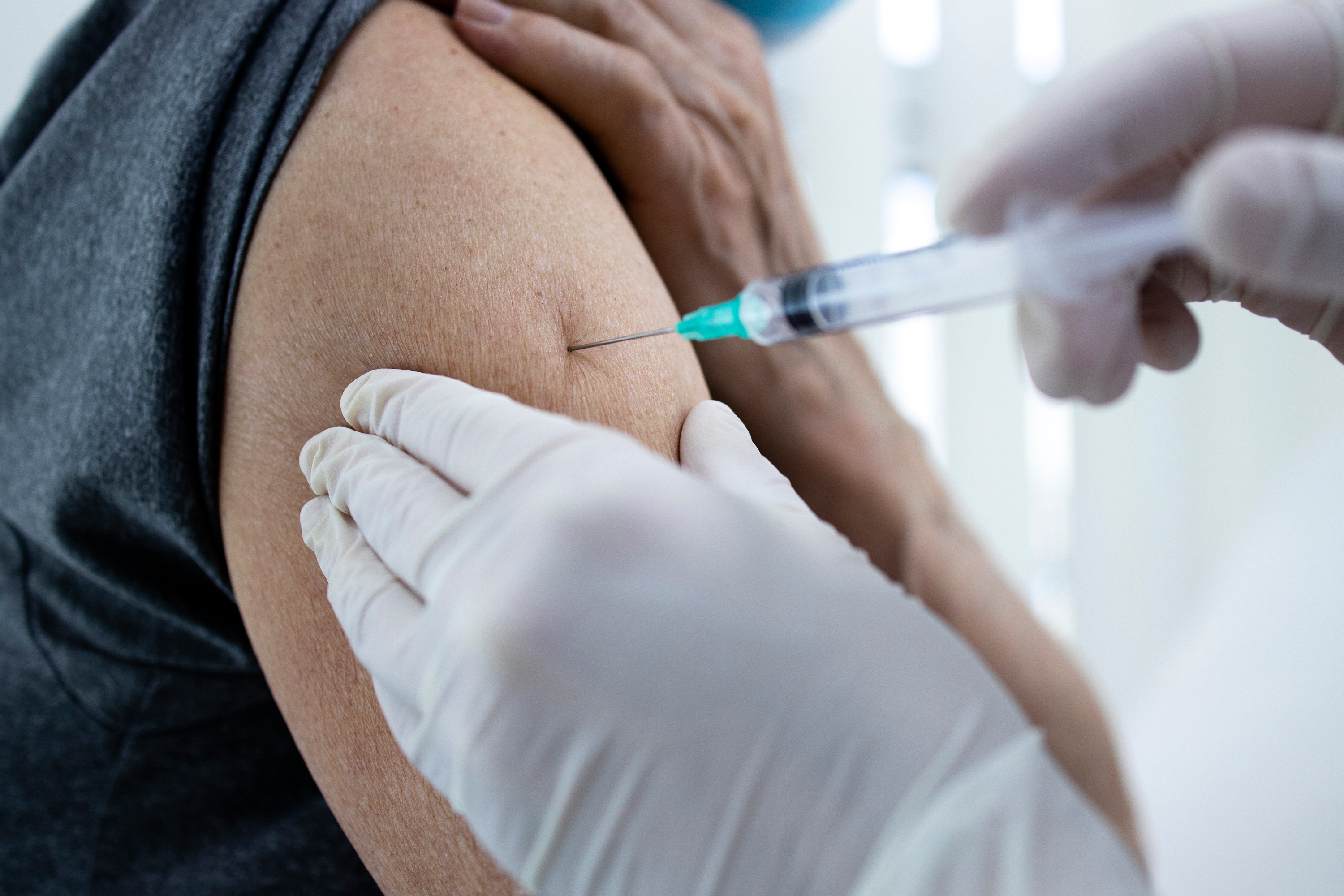 Close up view of an elderly man getting vaccine shot in his arm