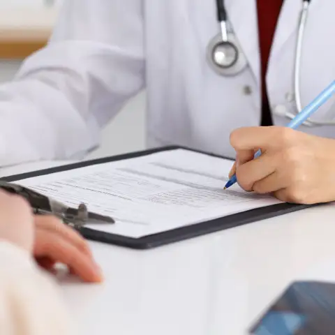 Doctor filling out a medical form for patient
