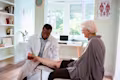 Doctor looking at senior woman’s leg