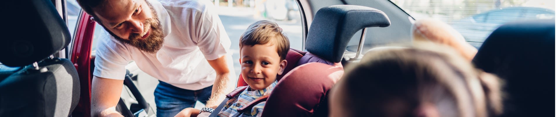 Shine Lawyers | Parent strapping children into car seats | Shine Lawyers