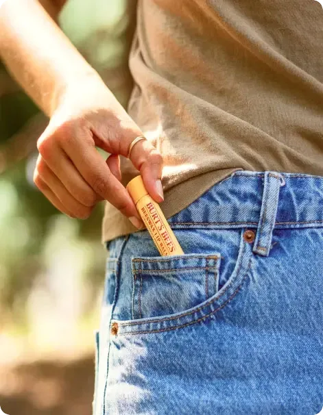 person putting lip balm in pocket