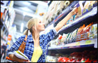 Photo of woman consumer reaching for products on store shelves.