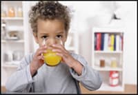 Photo of young child sipping acidic orange juice without a straw.