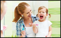 Photo of mother and young daughter practicing good oral hygiene.