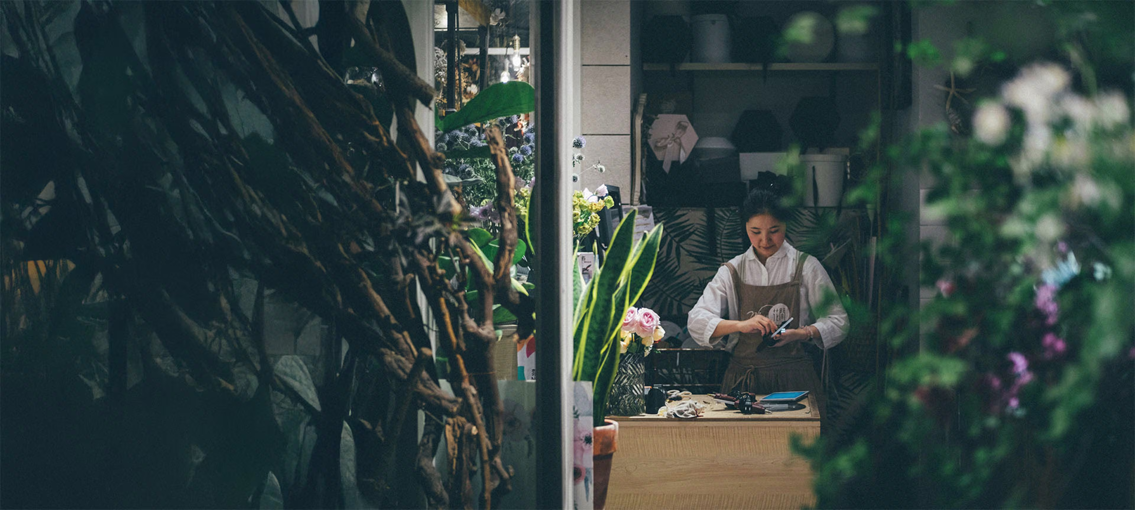 Smiling woman tending plants in her small business shop, representing success with a Small Business Line of Credit