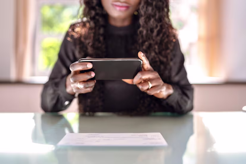 Woman taking a photo of a check with her phone