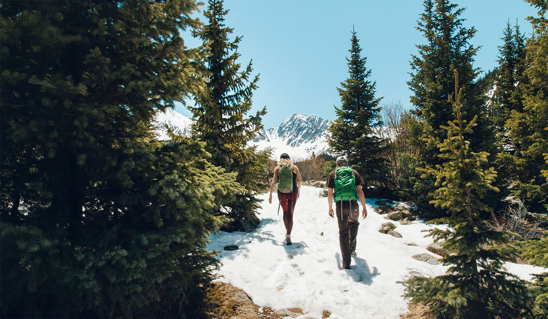 Couple hiking through snowy mountains.