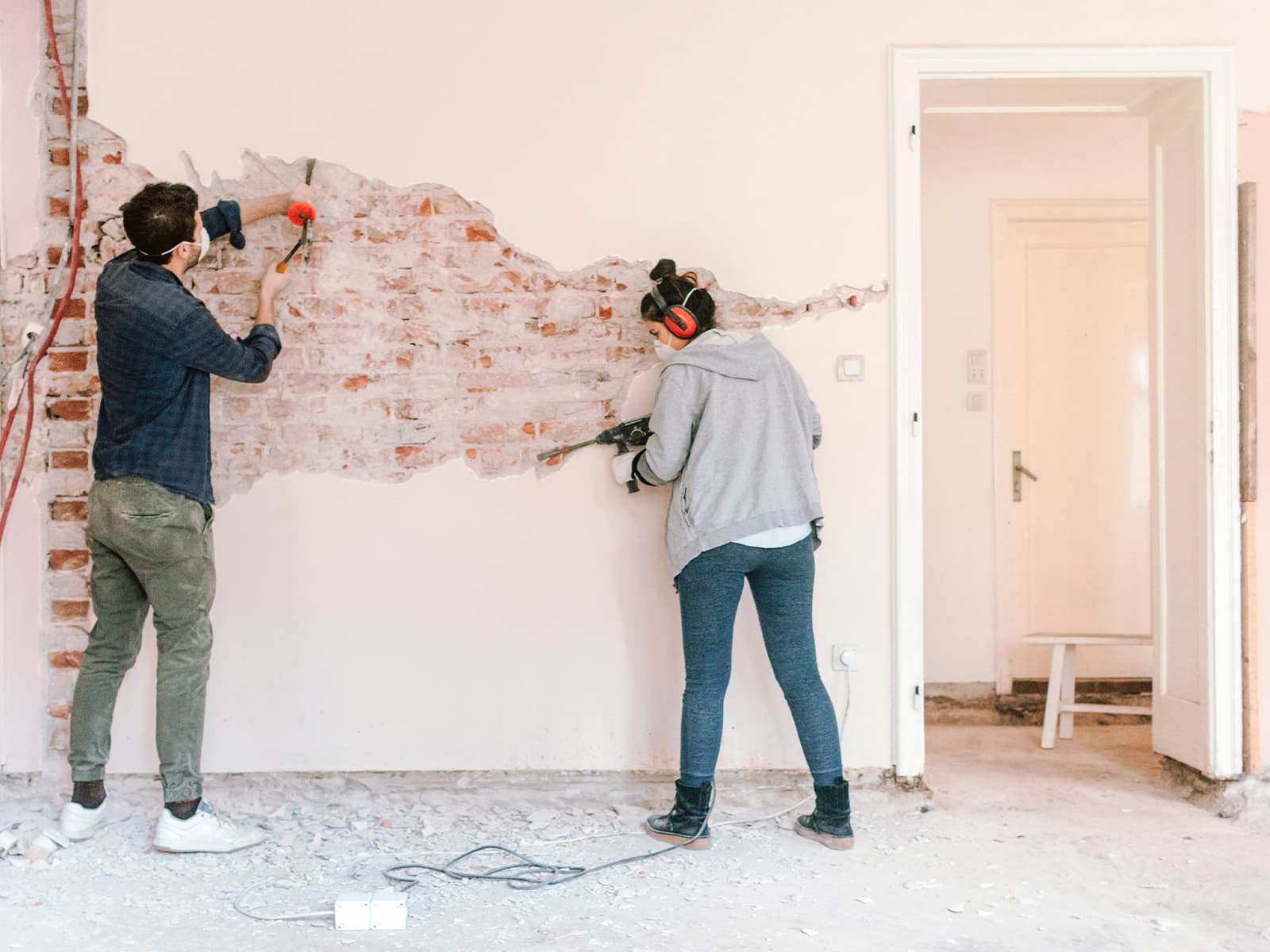 Man and woman fixing drywall