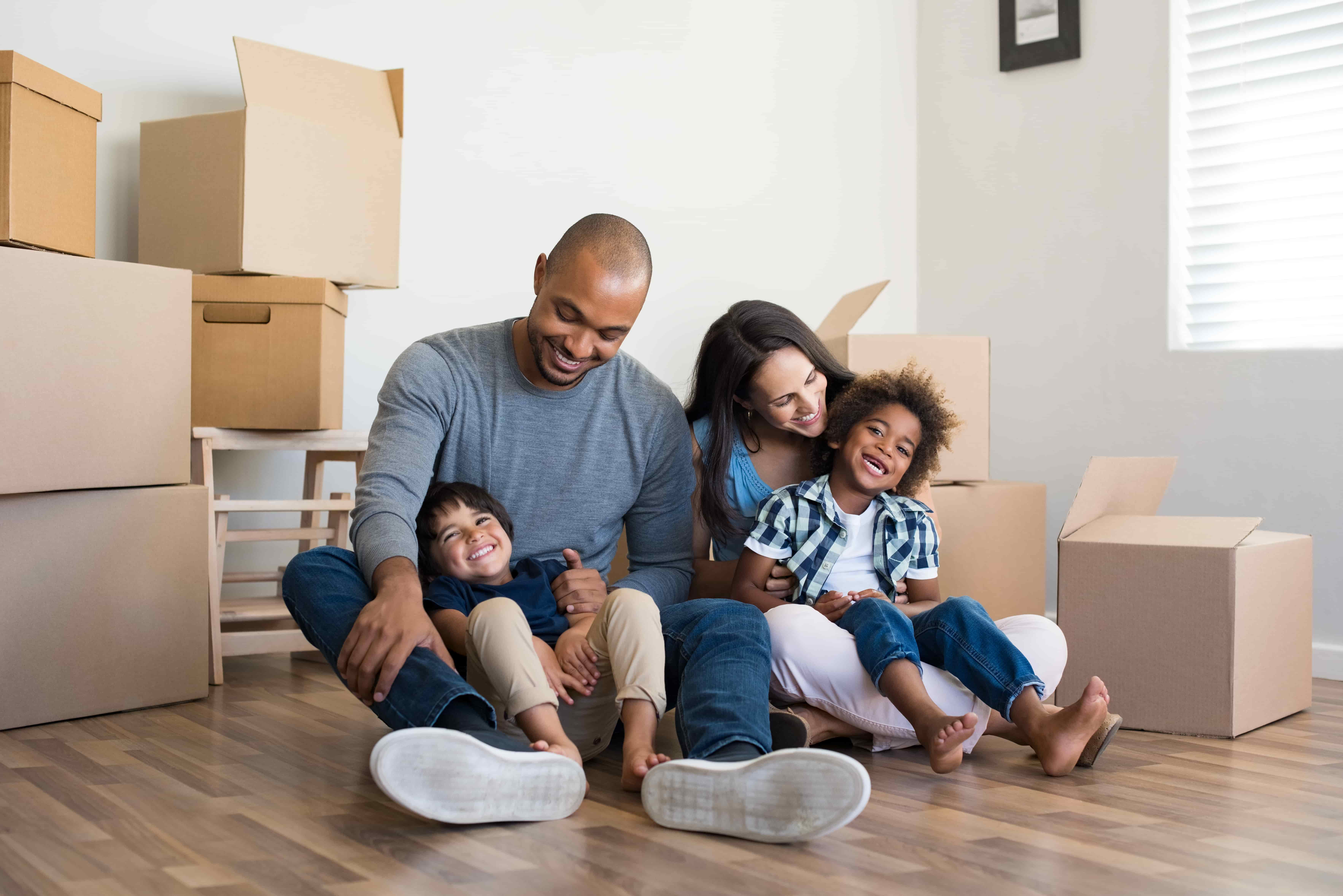 Family in a living room playing amongst moving boxes