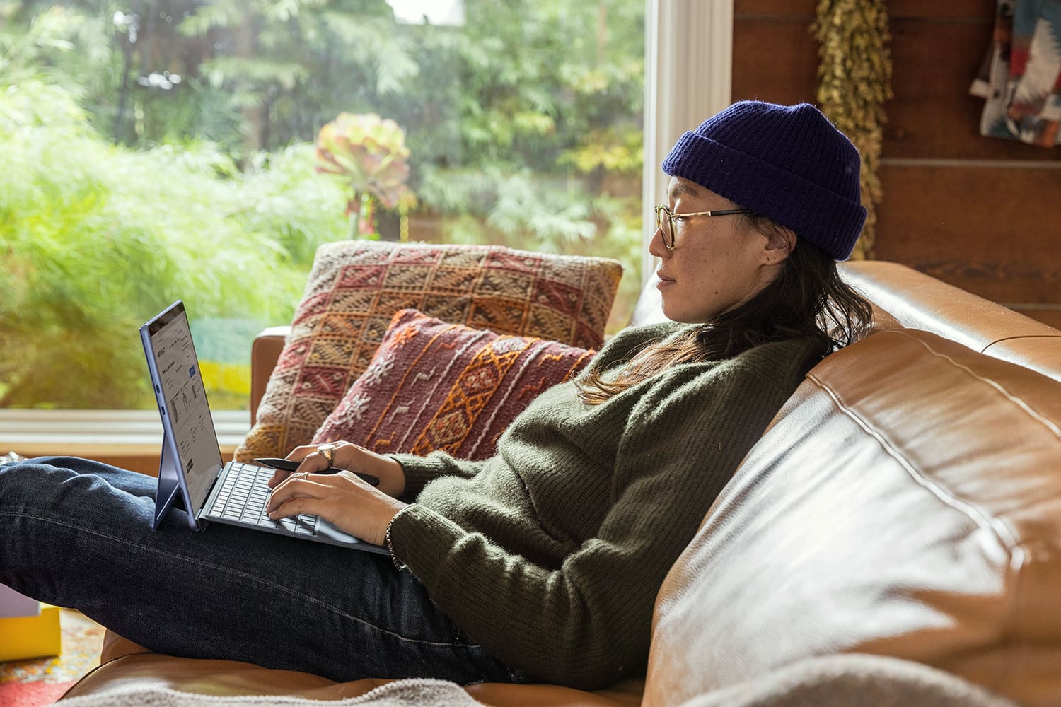 Woman on a couch using a laptop