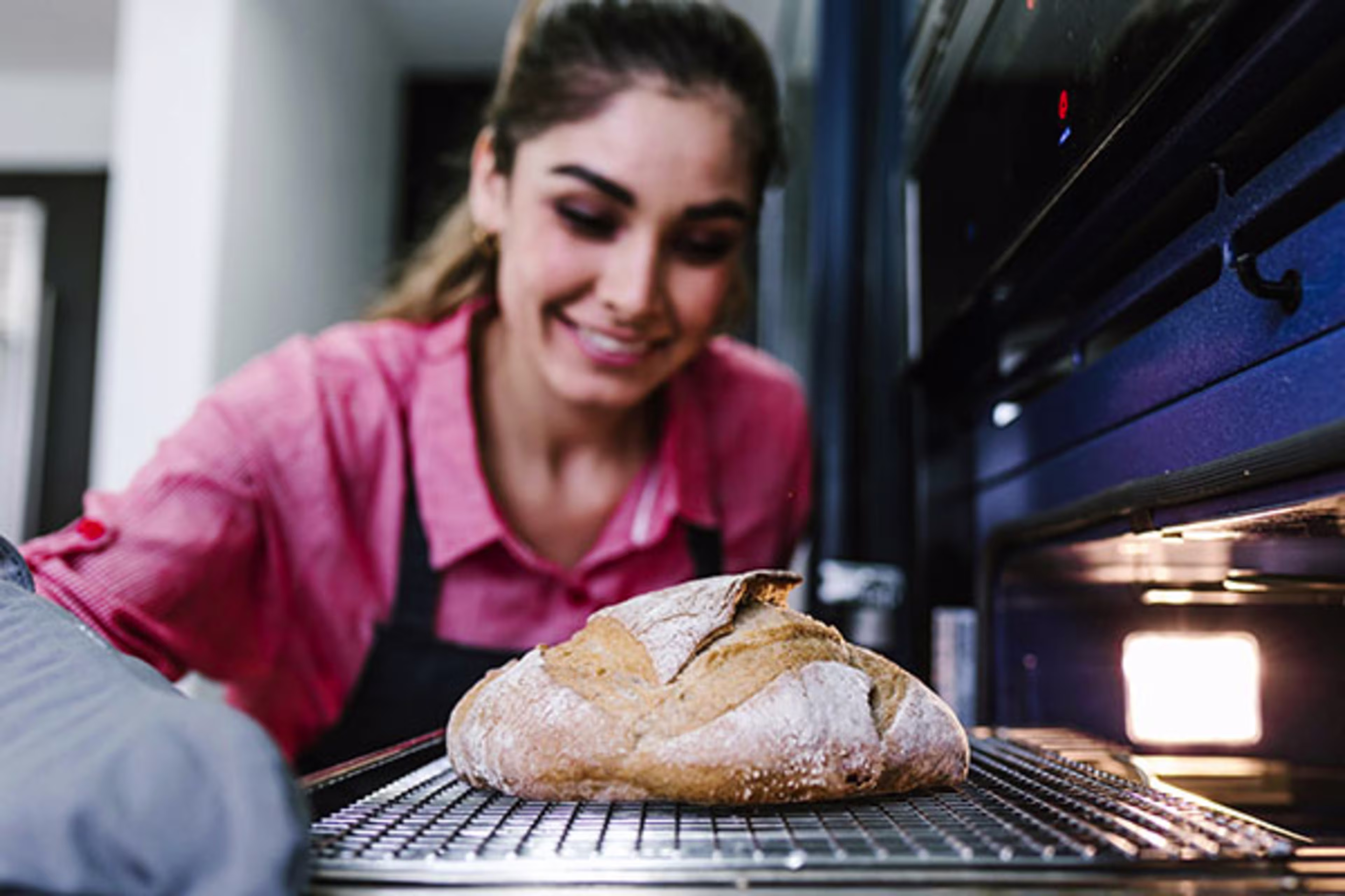 Woman baking fresh bread in a home kitchen, highlighting the comfort and personalization made possible through home improvement and renovation—supported by home improvement loans and construction loans.