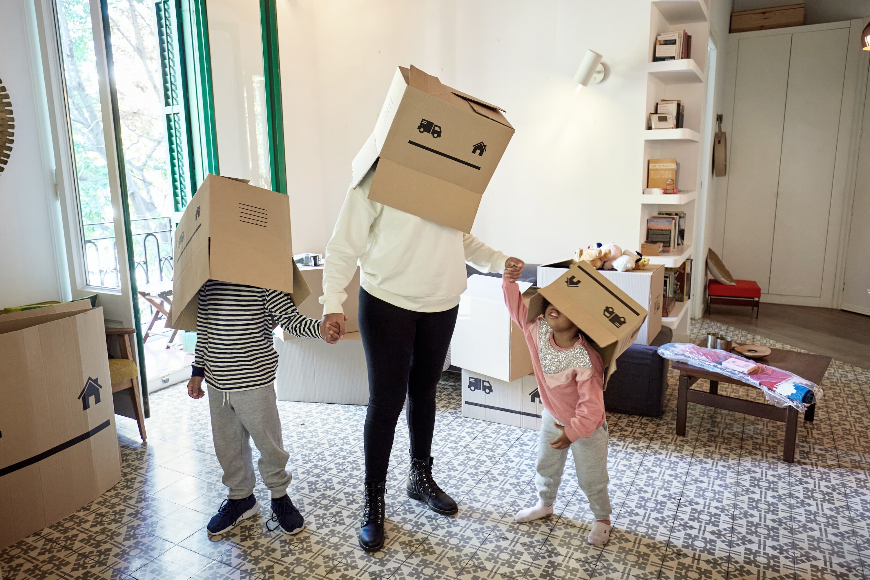 Family with moving boxes on their heads, dressed as robots