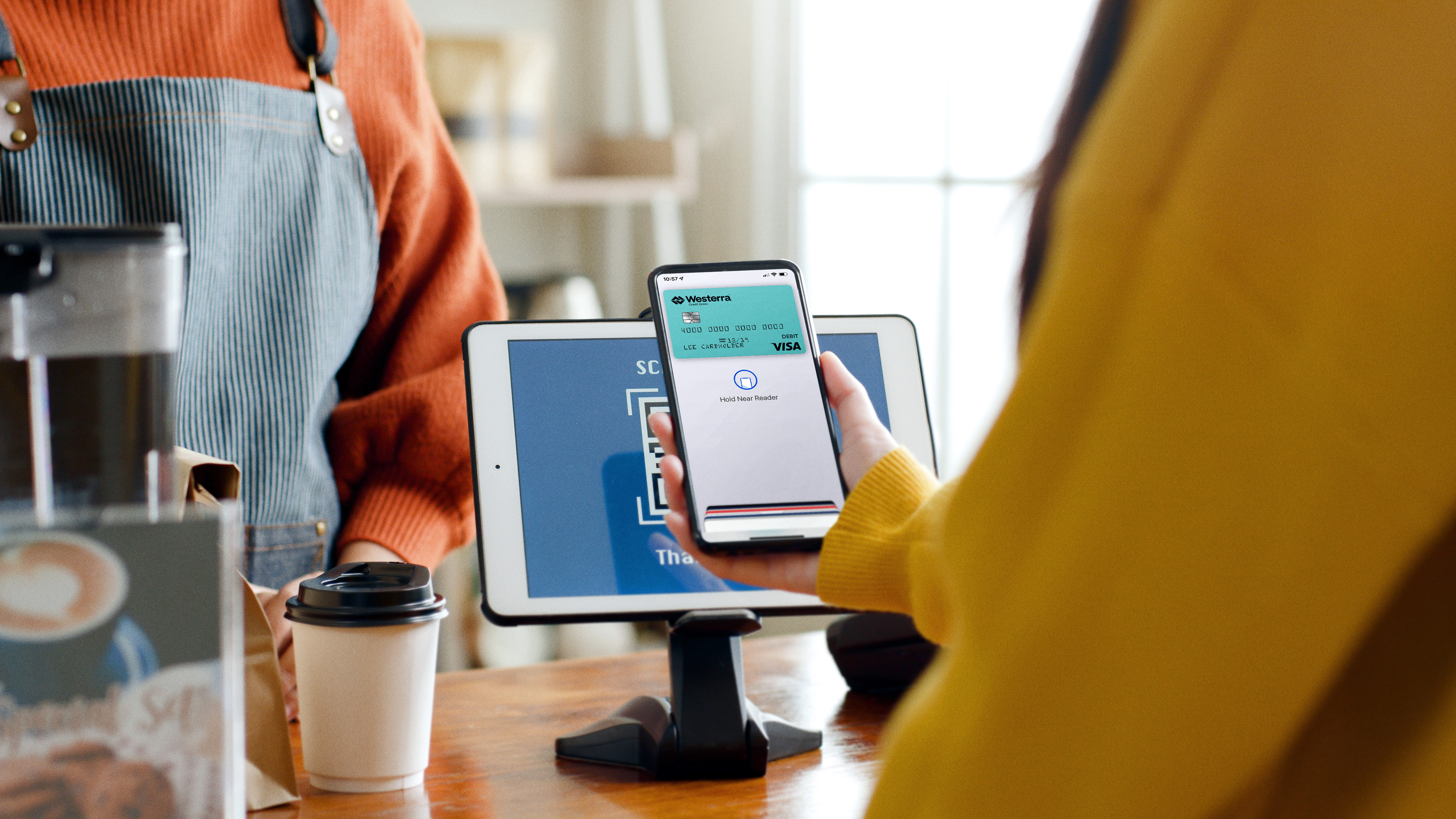 Person holding phone to pay at a coffee shop.