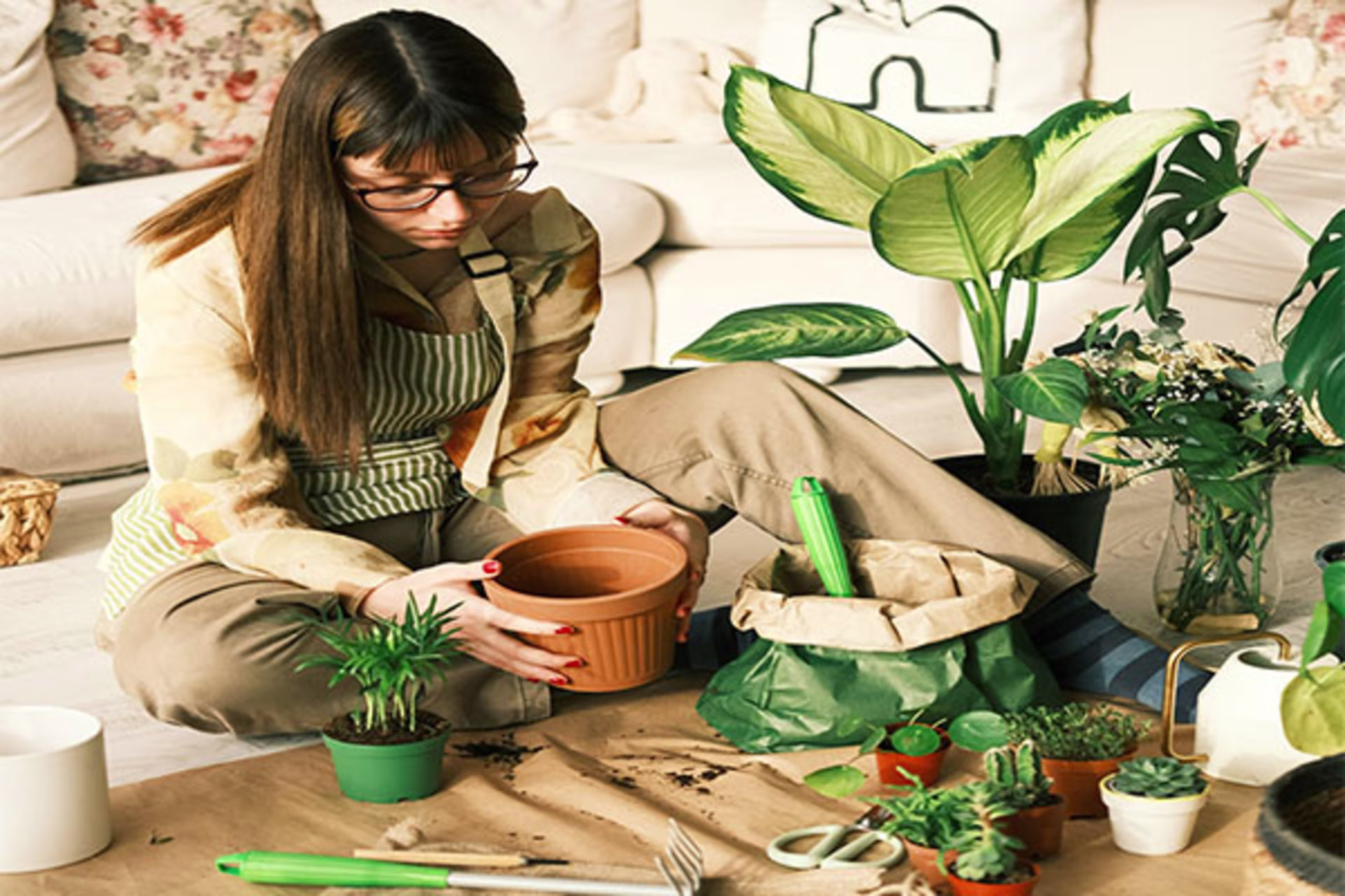 Woman potting plants in a beautifully renovated home, reflecting the personal touches and outdoor enhancements made possible through home improvement loans and construction financing.
