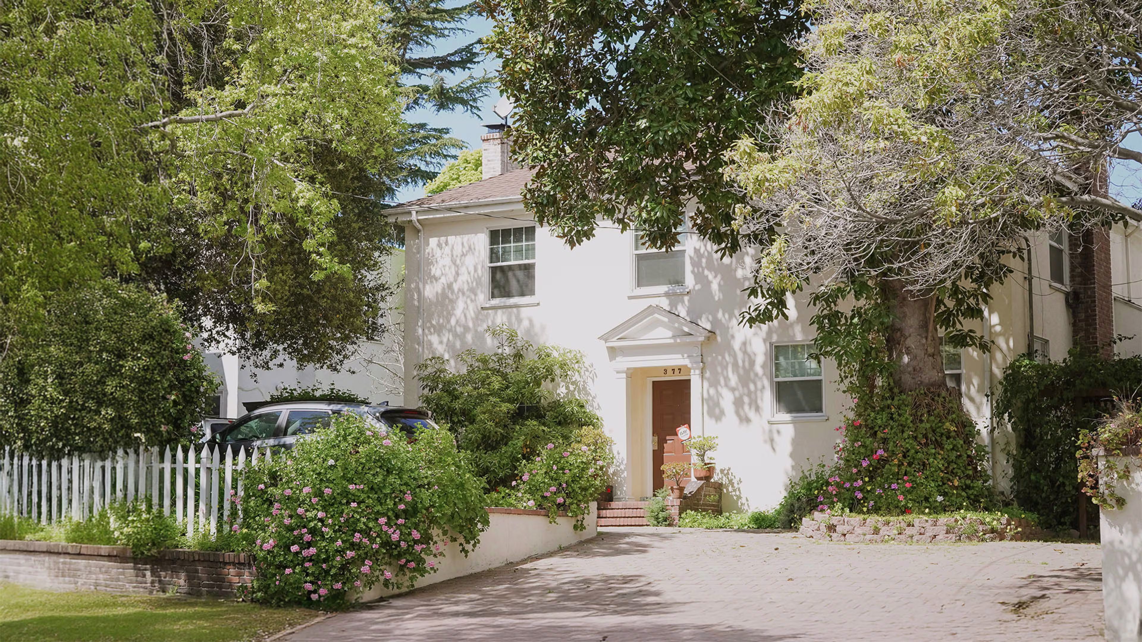 Beautiful white house surrounded by trees, representing the flexibility of Adjustable-Rate Mortgages (ARM) and 5-Year ARM options for homeowners looking to refinance or explore adjustable rate mortgages.