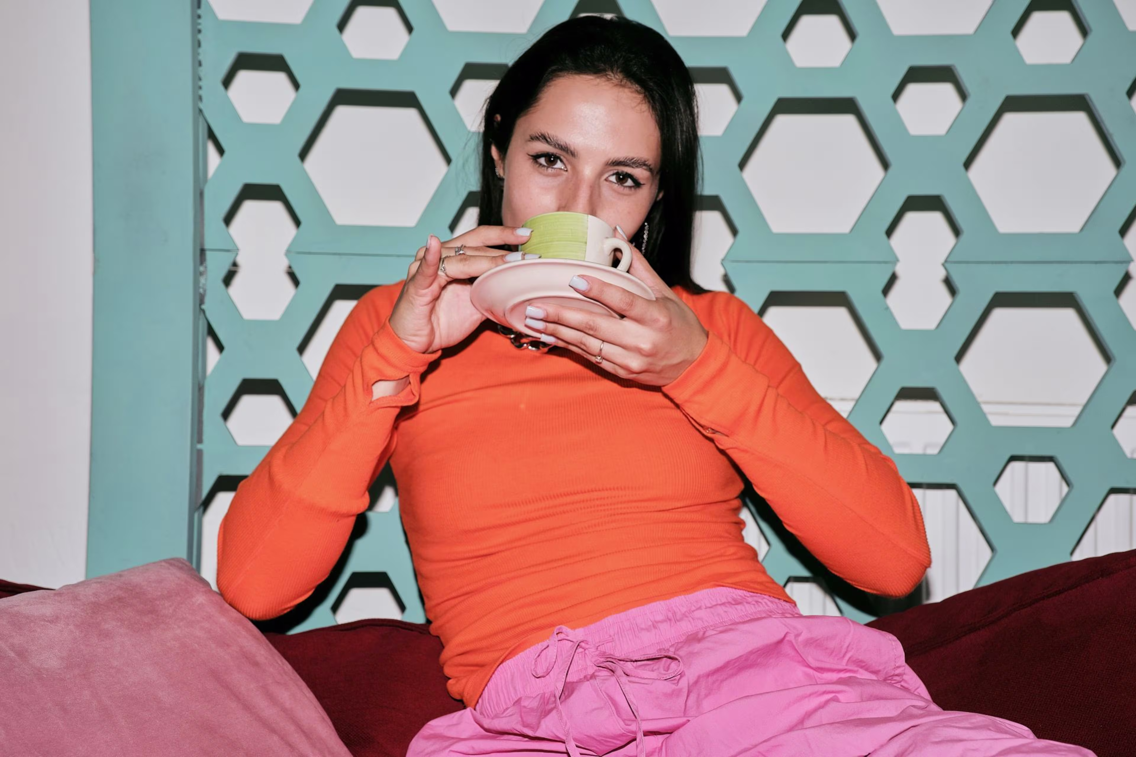 Lady drinking tea against a blue hexagonal background with text 'Interest Paid to Members' highlighting the benefits of credit unions.