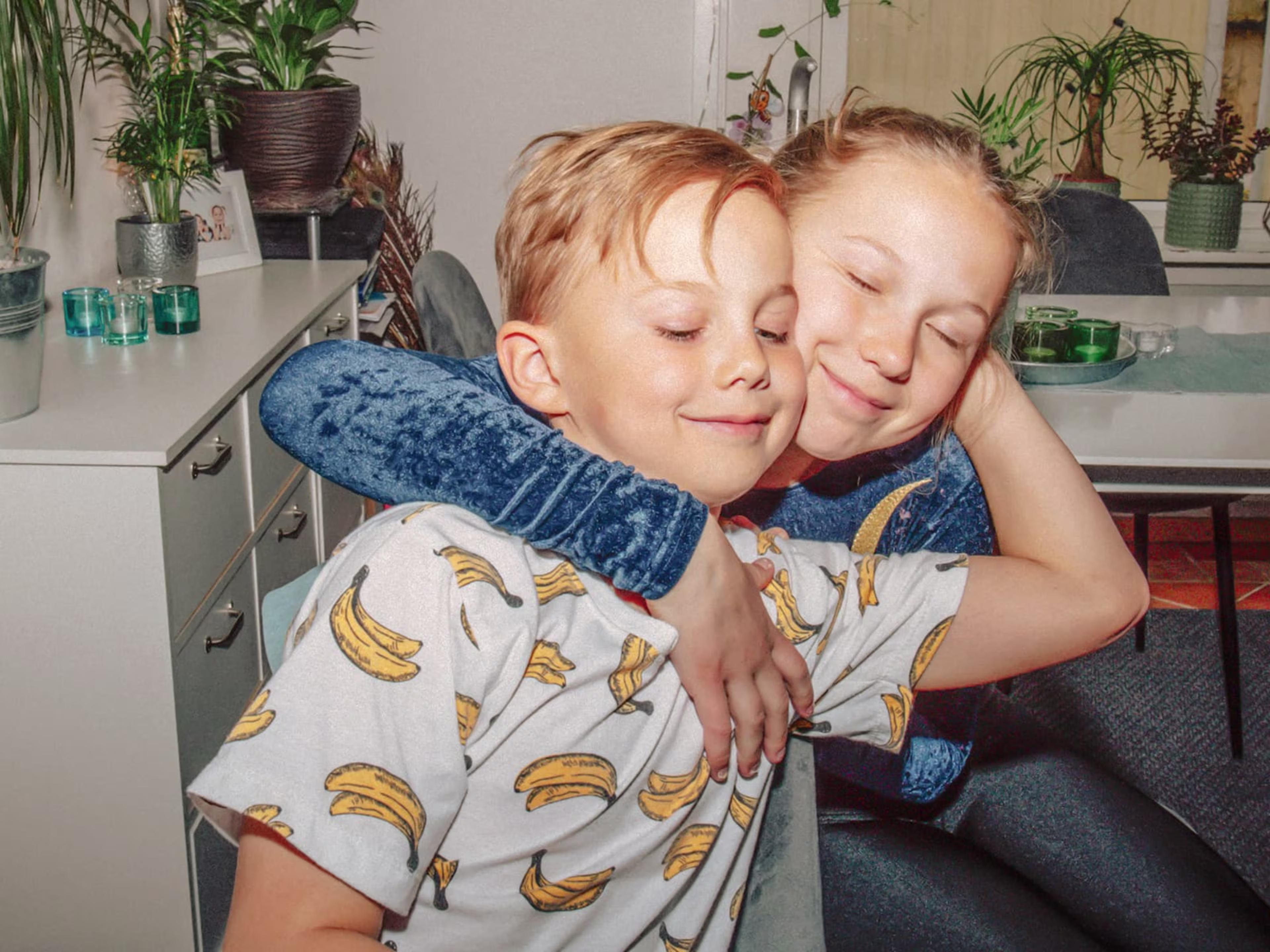 Girl and boy siblings hugging each other