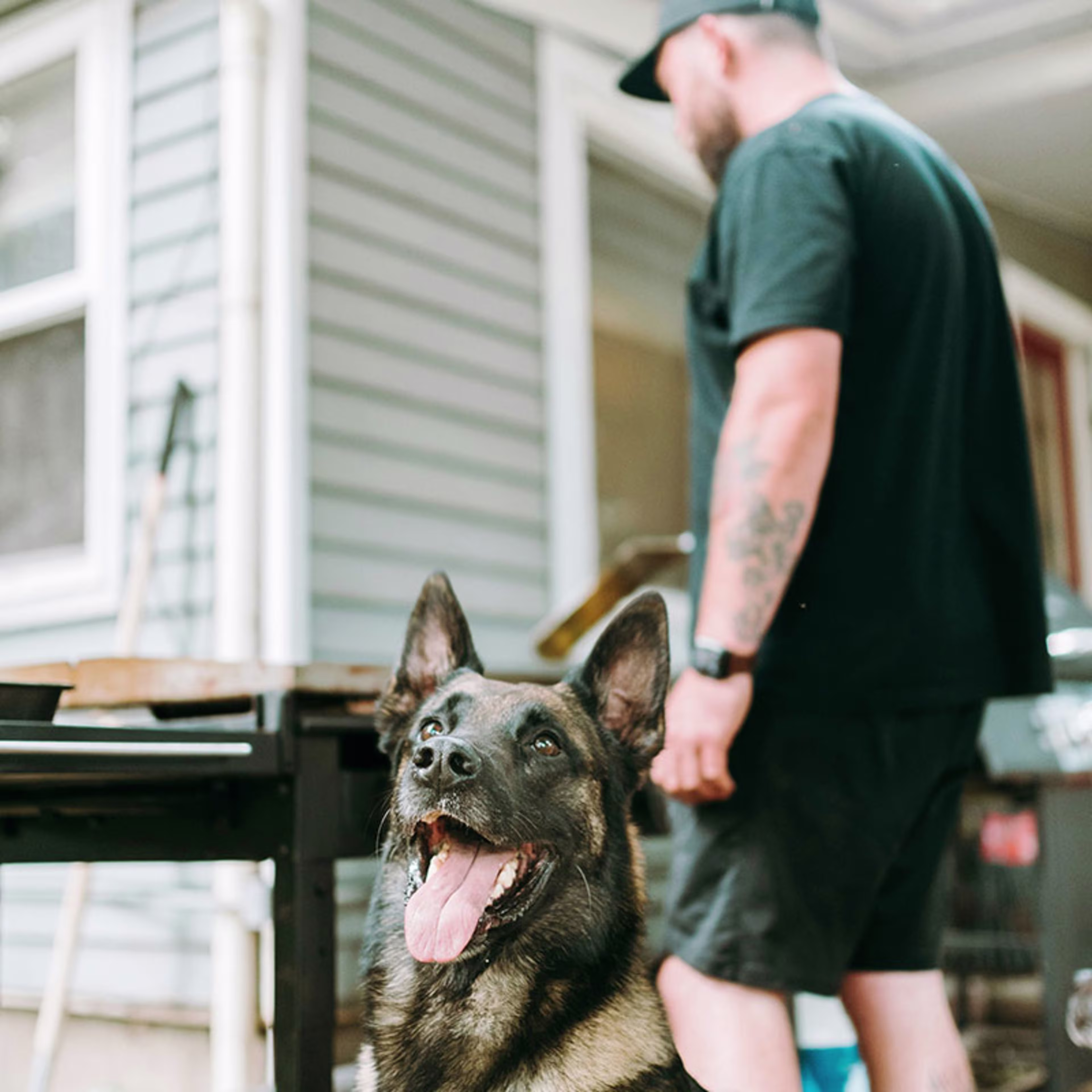 Man grilling outdoors with his dog nearby, enjoying the comfort of home made possible through VA Home Loans, VA Mortgage Loans, and home improvement financed by a VA Loan.
