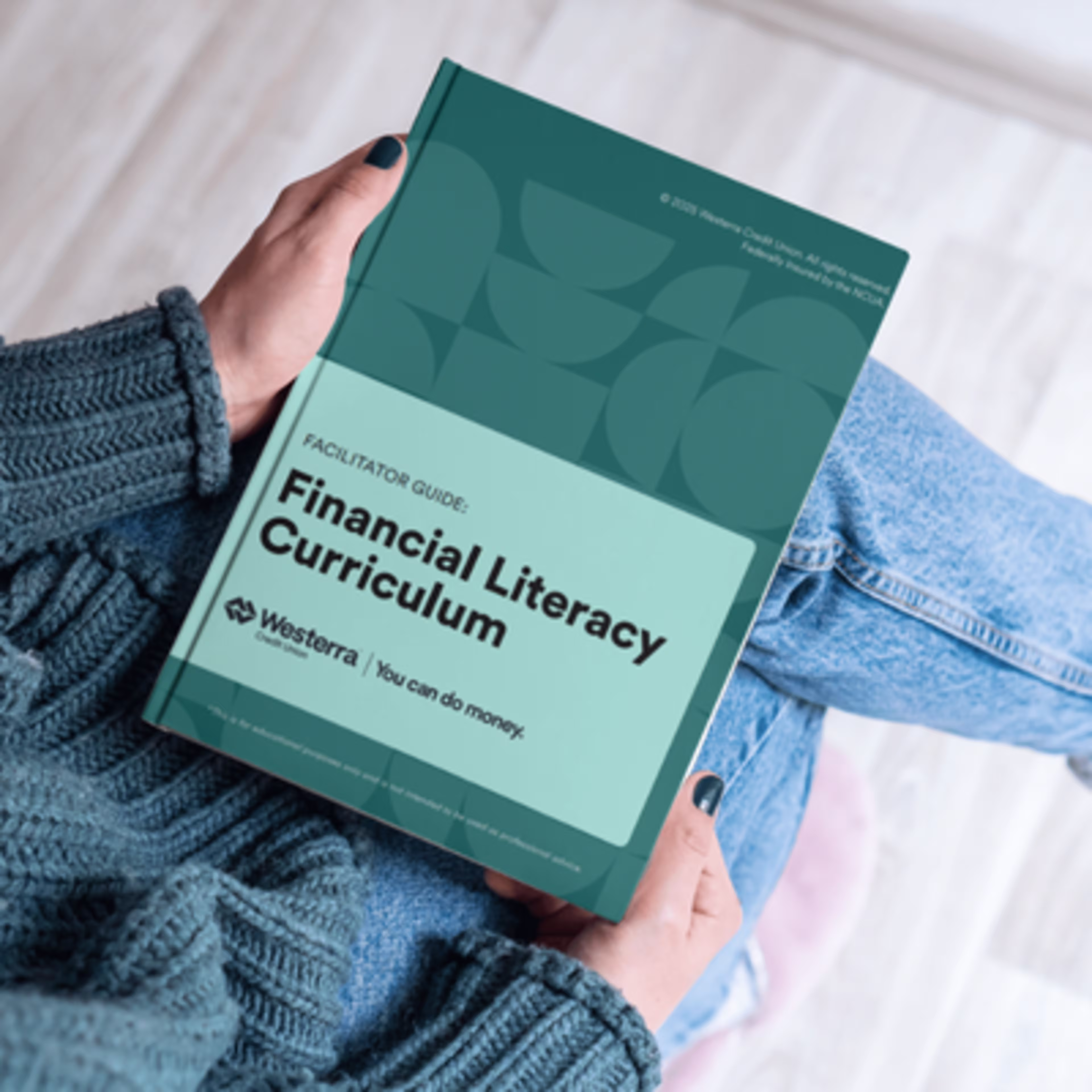 Teacher Holding Westerra Credit Unions Financial Literacy Curriculum
