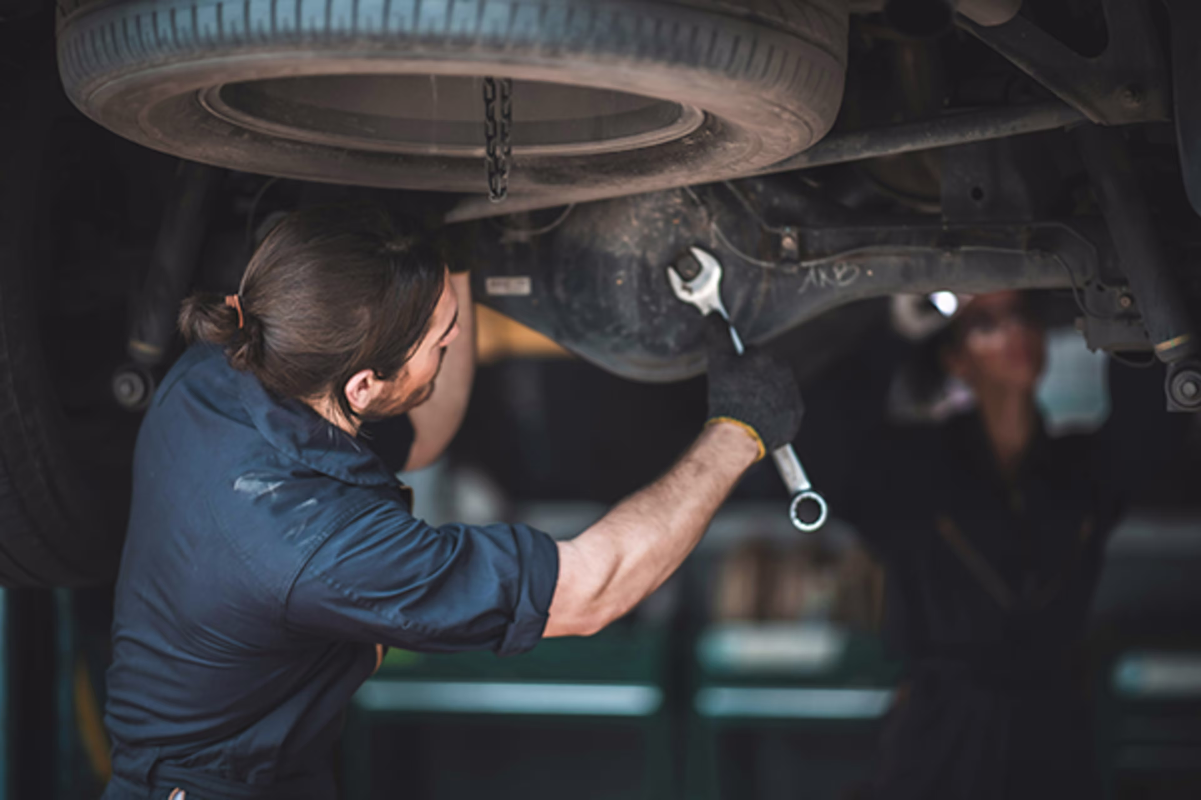 Man working on a car engine, representing a Colorado small business owner using Westerra’s small business online banking with bill pay and online bill pay service to manage money easily and securely.