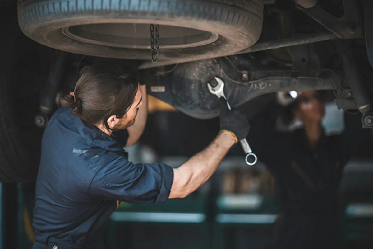 Man working on a car engine, representing a Colorado small business owner using Westerra’s small business online banking with bill pay and online bill pay service to manage money easily and securely.