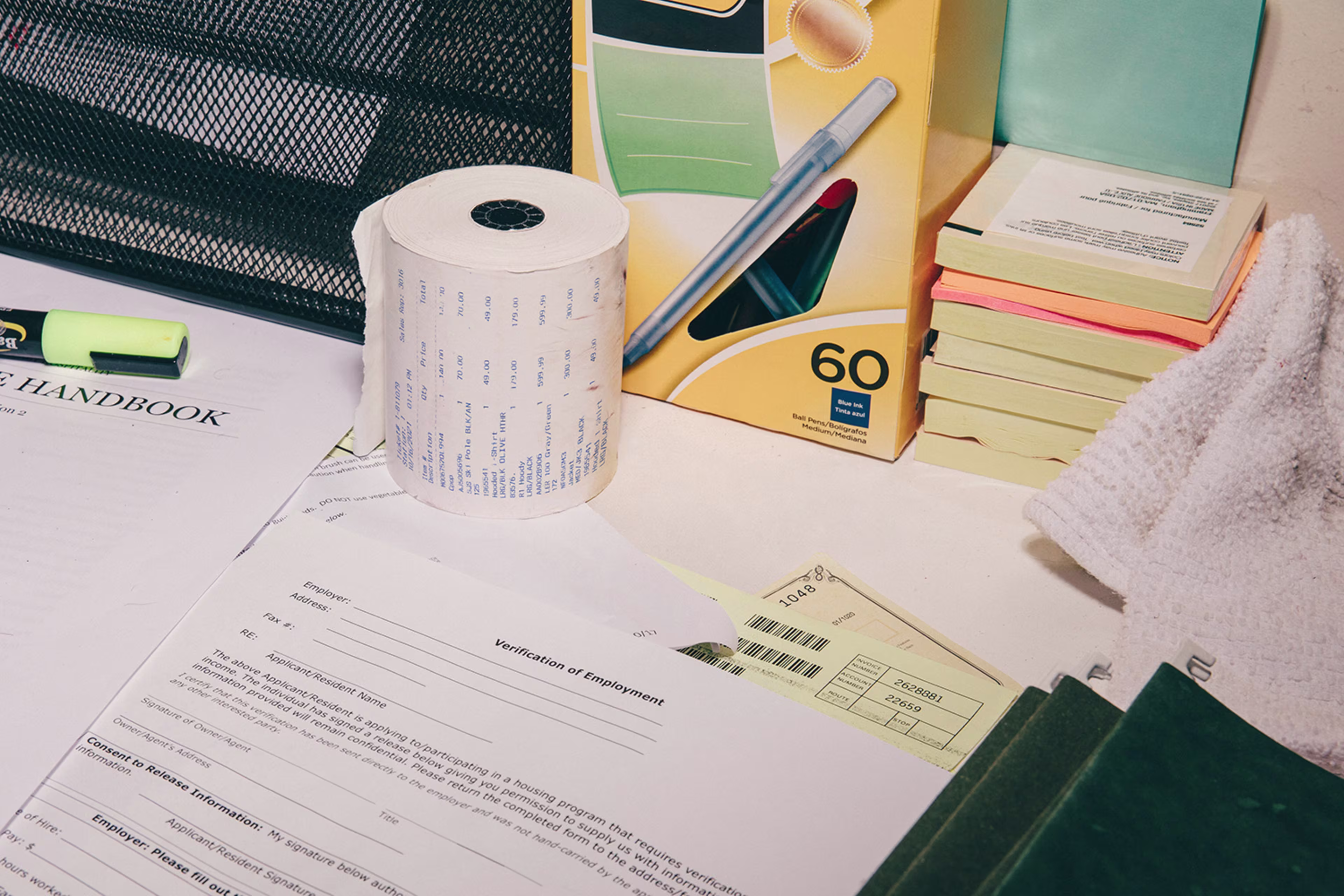 Papers, box of pens, toilet paper roll, heaps of sticky notes