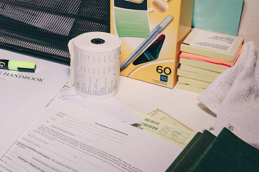 Papers, box of pens, toilet paper roll, heaps of sticky notes