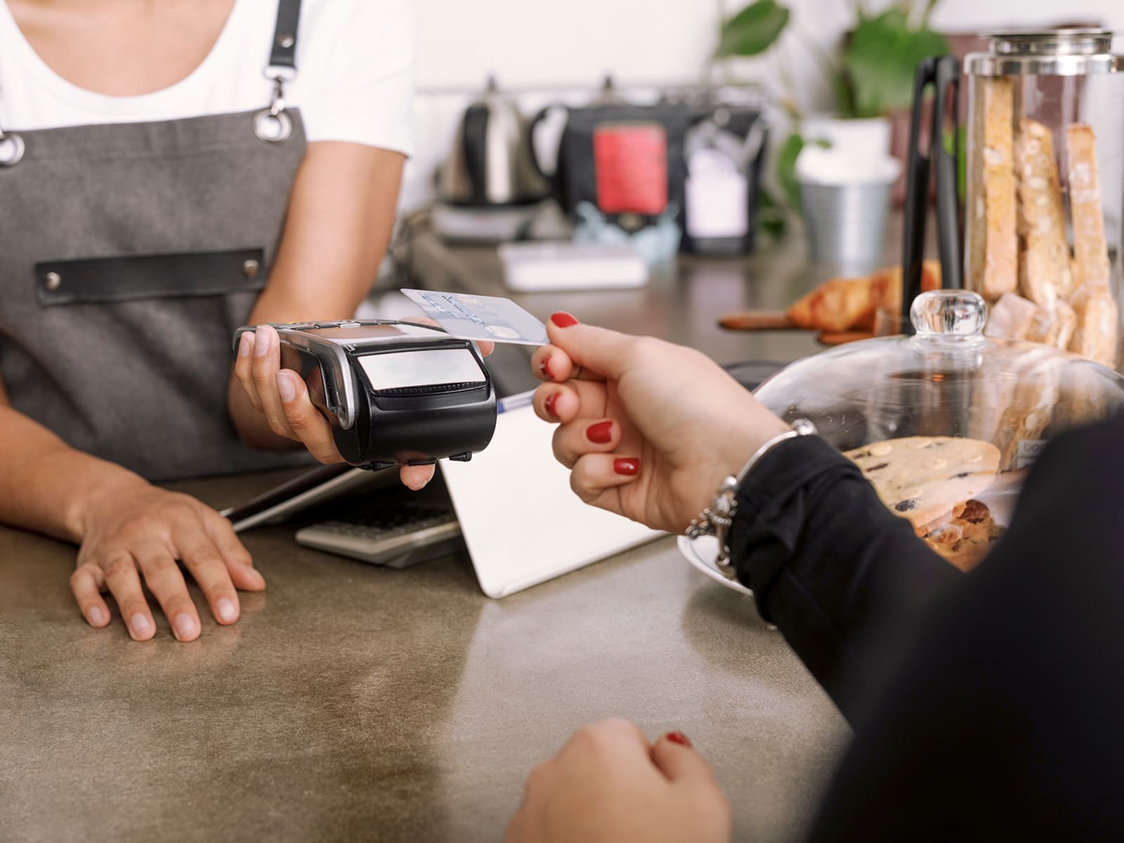 Woman holding her credit card to a card reader