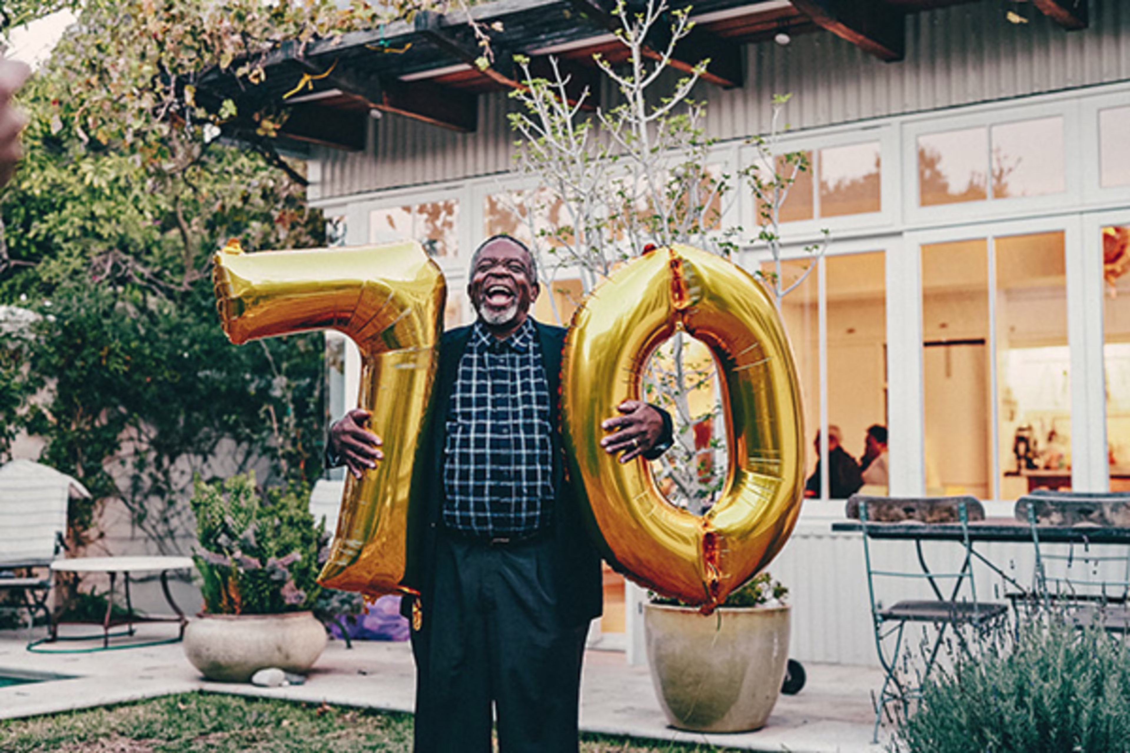 Happy Man Celebrating a Milestone with 70 Balloons