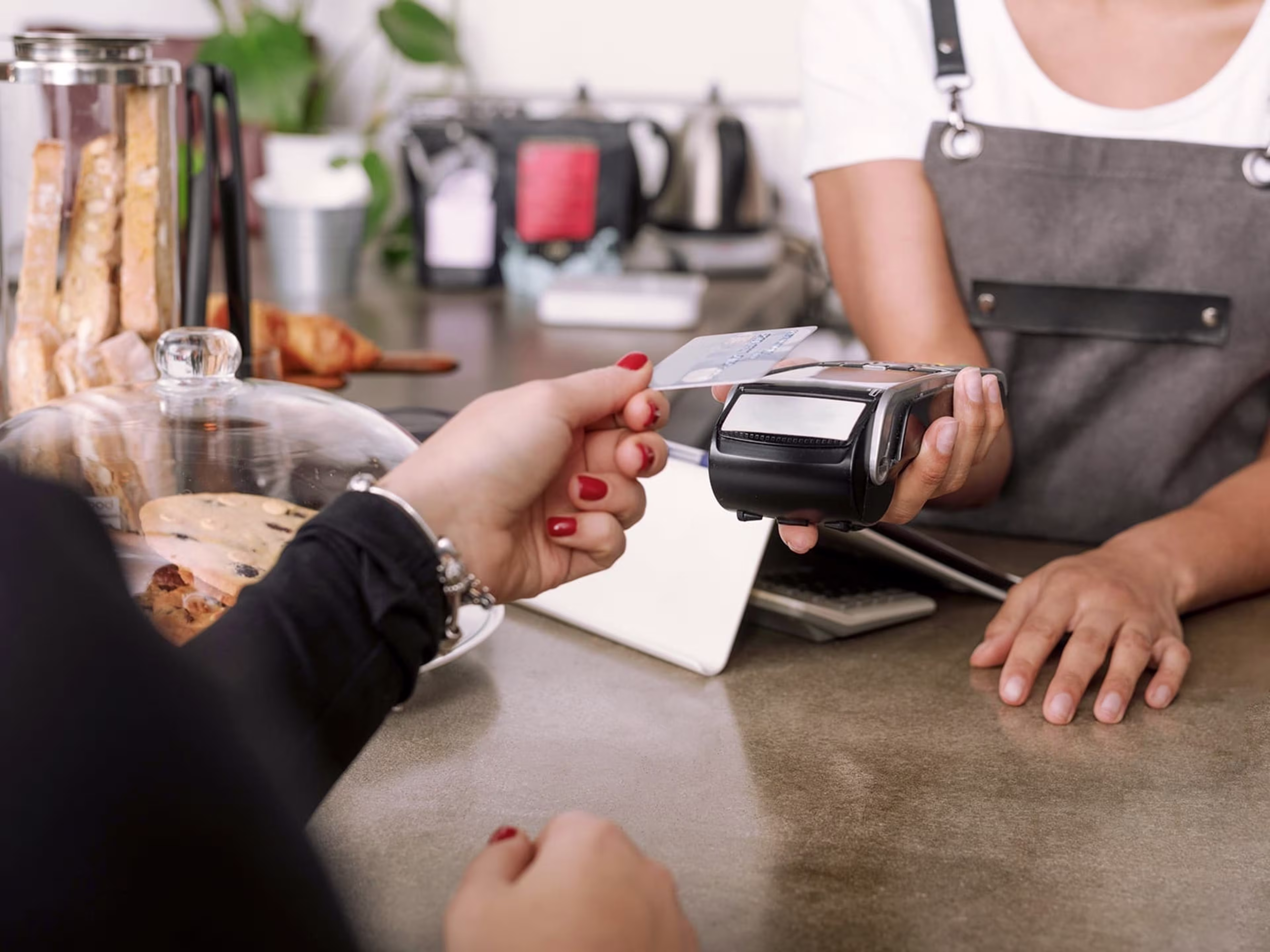 Woman holding her credit card to a card reader