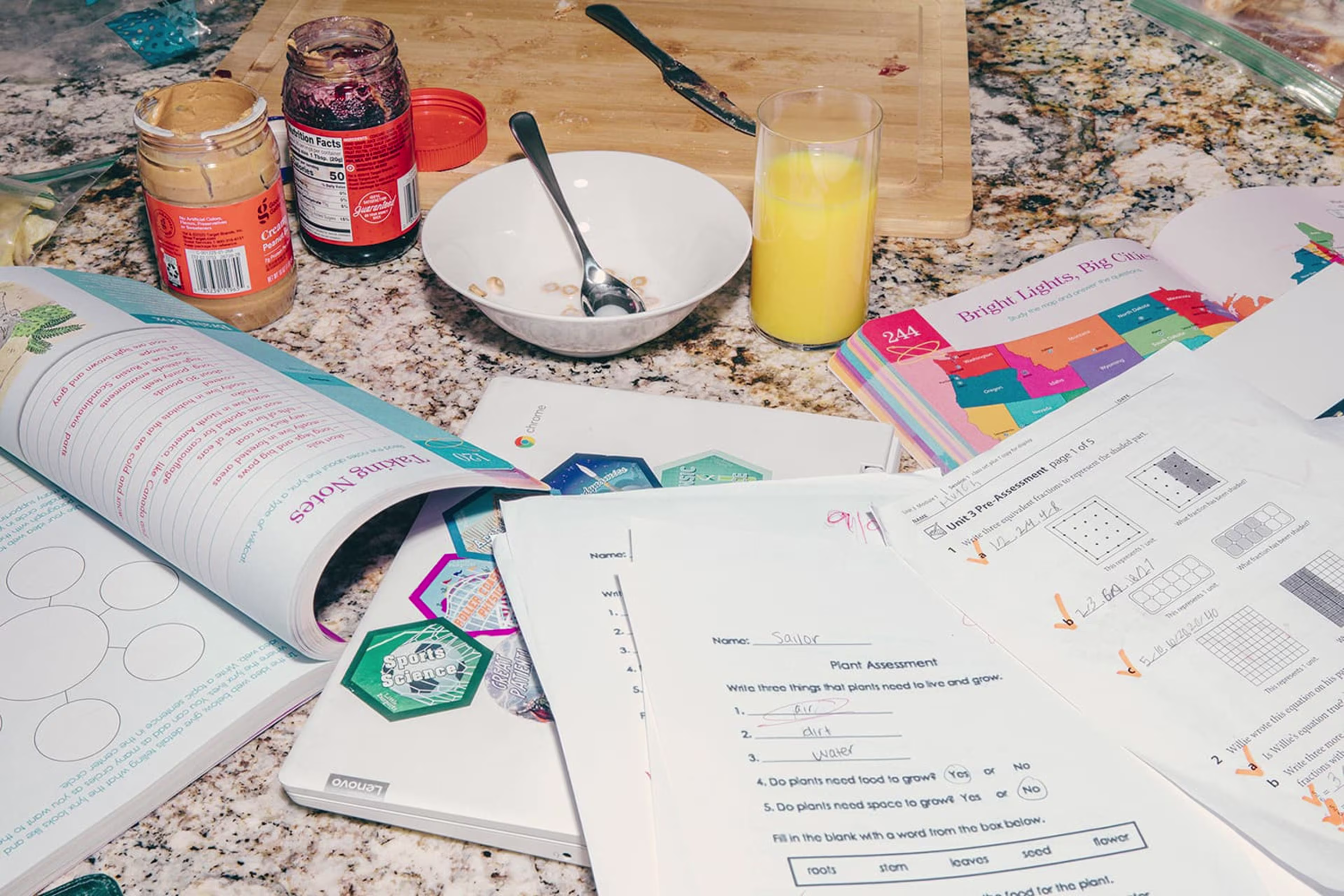 Countertop with open peanut butter and jelly jars, bowl of cereal, glass of orange juice, and multiple open textbooks