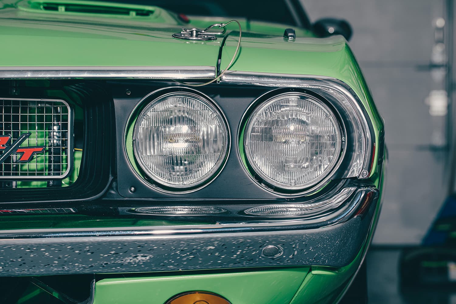 Close-up of the headlight of a green Mustang