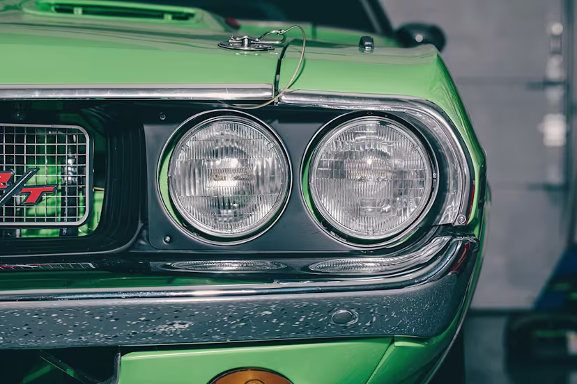 Close-up of the headlight of a green Mustang