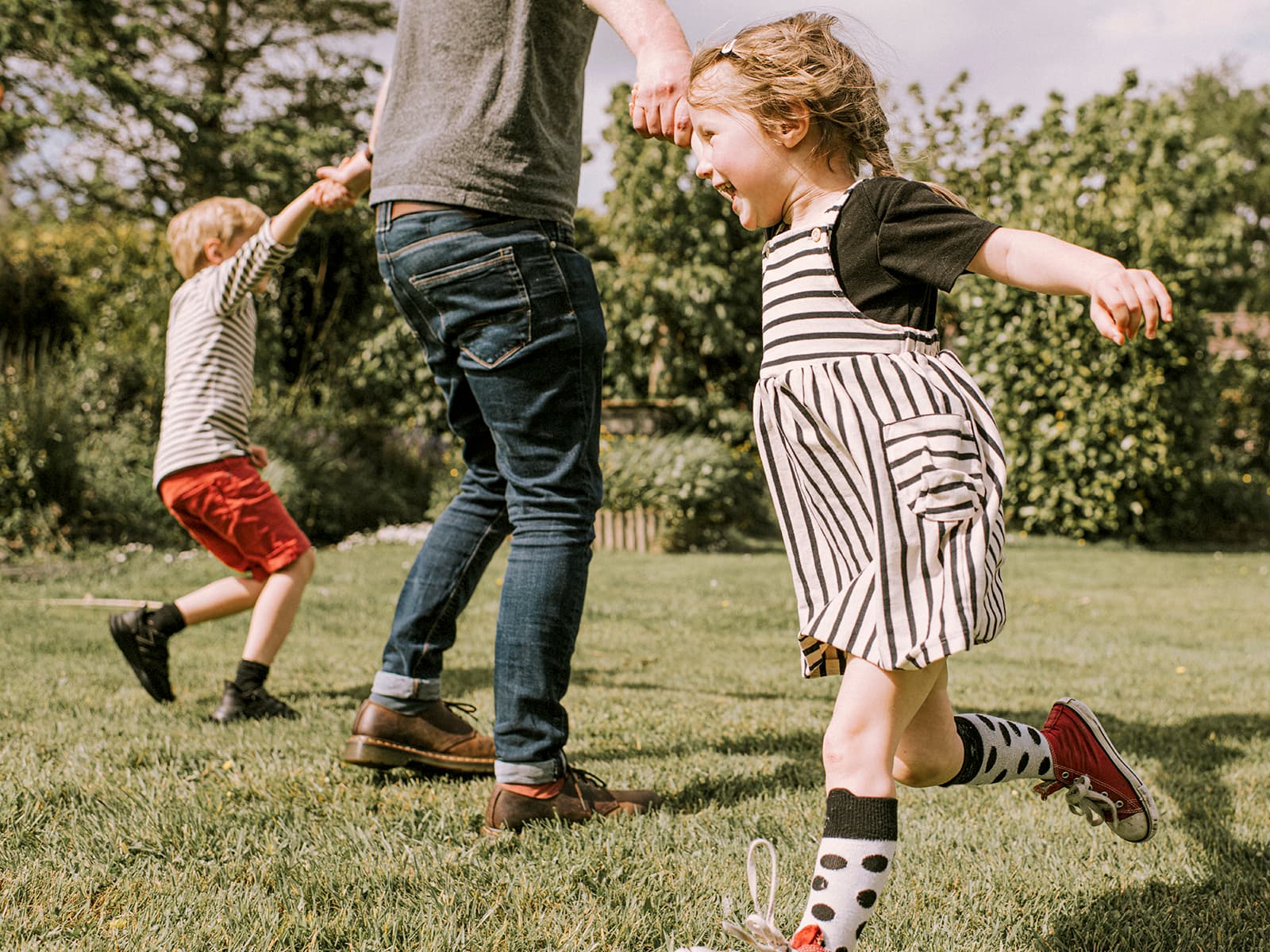 Dad playing with his two children outside