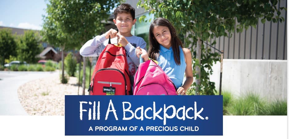 Children holding backpacks to support a School Supply Drive. 