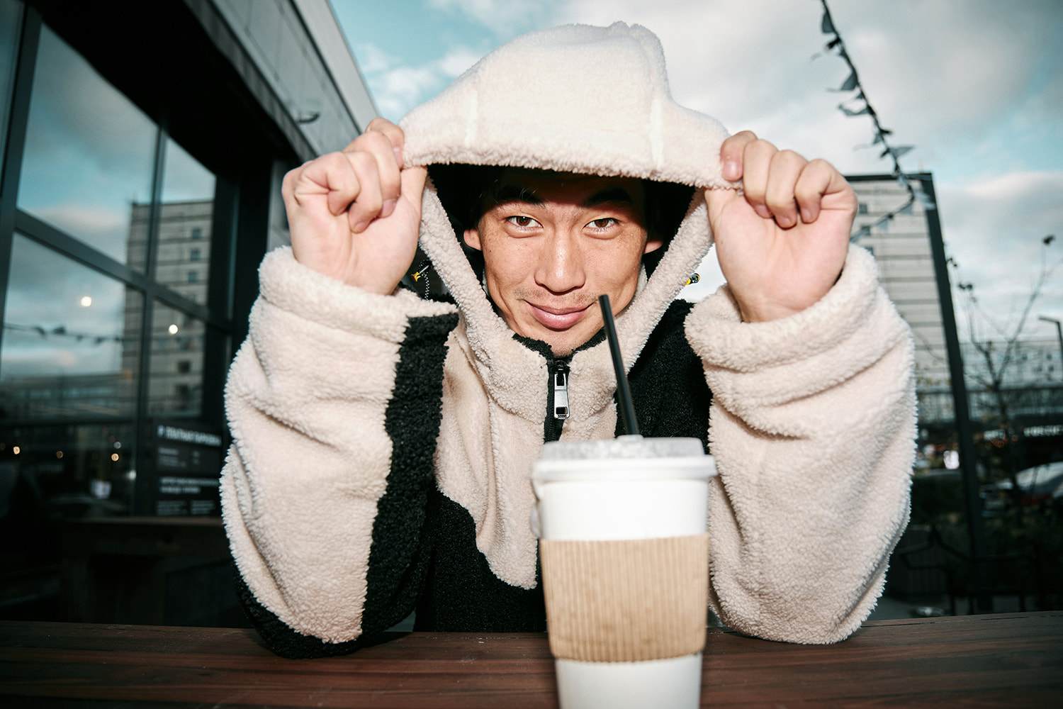 Man with white hoodie drinking coffee