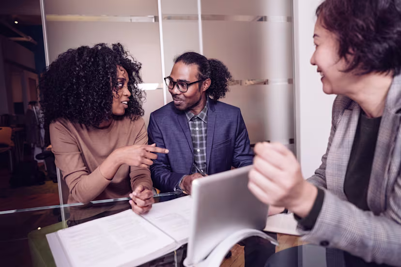 Three people at a table looking at mortgage paperwork