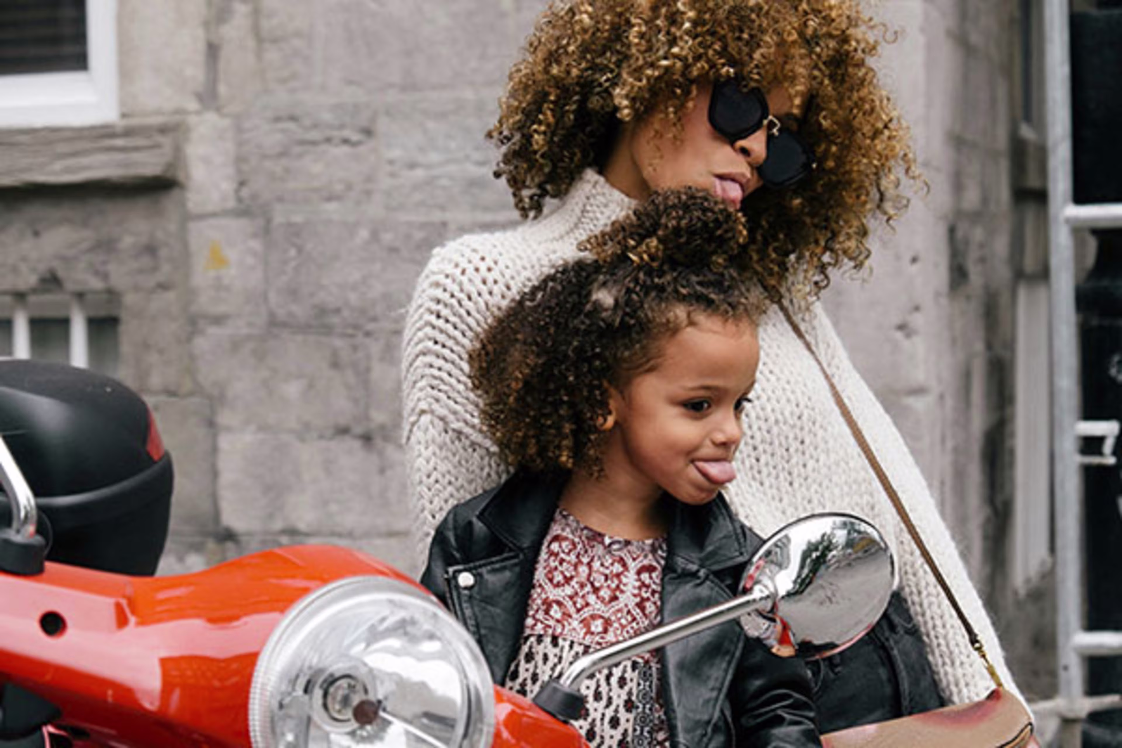 Mother and daughter making a goofy face in a motorcycle mirror, symbolizing the fun and flexibility that Bridge Loans can offer—helping you transition smoothly between homes with ease and confidence.